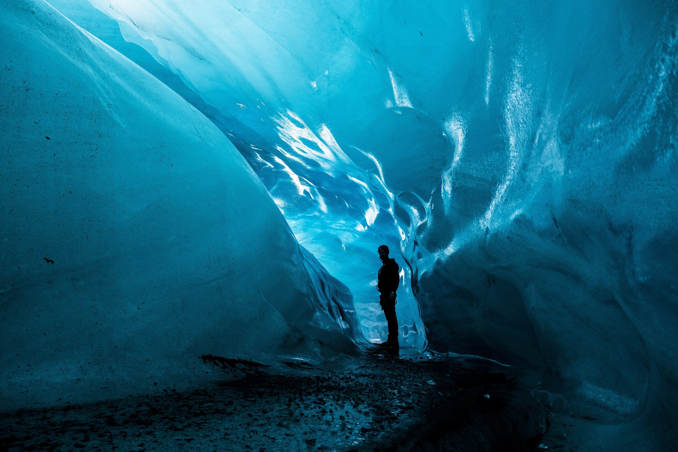A traveller inside a blue ice cave under Vatnajökull